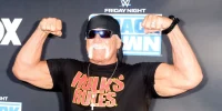 Hulk Hogan posa para fotos no evento Friday Night SmackDown da WWE, exibindo seu visual clássico com a camiseta "Hulk's Rules" e seu tradicional gesto de força.