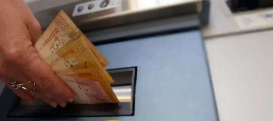 Segurado realizando operação financeira relacionada ao pagamento de benefícios do INSS, conforme calendário oficial de agosto.