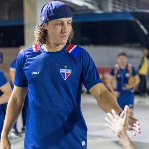 Jogadores do Fortaleza se preparam para viagem momentos após o anúncio oficial da saída de David Luiz, que foi contratado pelo Pafos FC, do Chipre.
📝 Descrição:
A imagem mostra atletas do Fortaleza Esporte Clube usando uniformes azuis com detalhes em vermelho e branco, instantes antes ou depois de uma movimentação oficial. Com mochilas e equipamentos esportivos, o grupo parece em trânsito para treino ou jogo, enquanto a presença de um ônibus ao fundo reforça a sensação de deslocamento. Em destaque, um jogador cumprimenta alguém com um sorriso, transmitindo camaradagem e clima de despedida. A saída de David Luiz para o Pafos FC marca o fim de sua passagem pelo clube cearense e o início de um novo desafio internacional.
Jogadores do Fortaleza se preparam para viagem momentos após o anúncio oficial da saída de David Luiz, que foi contratado pelo Pafos FC, do Chipre.